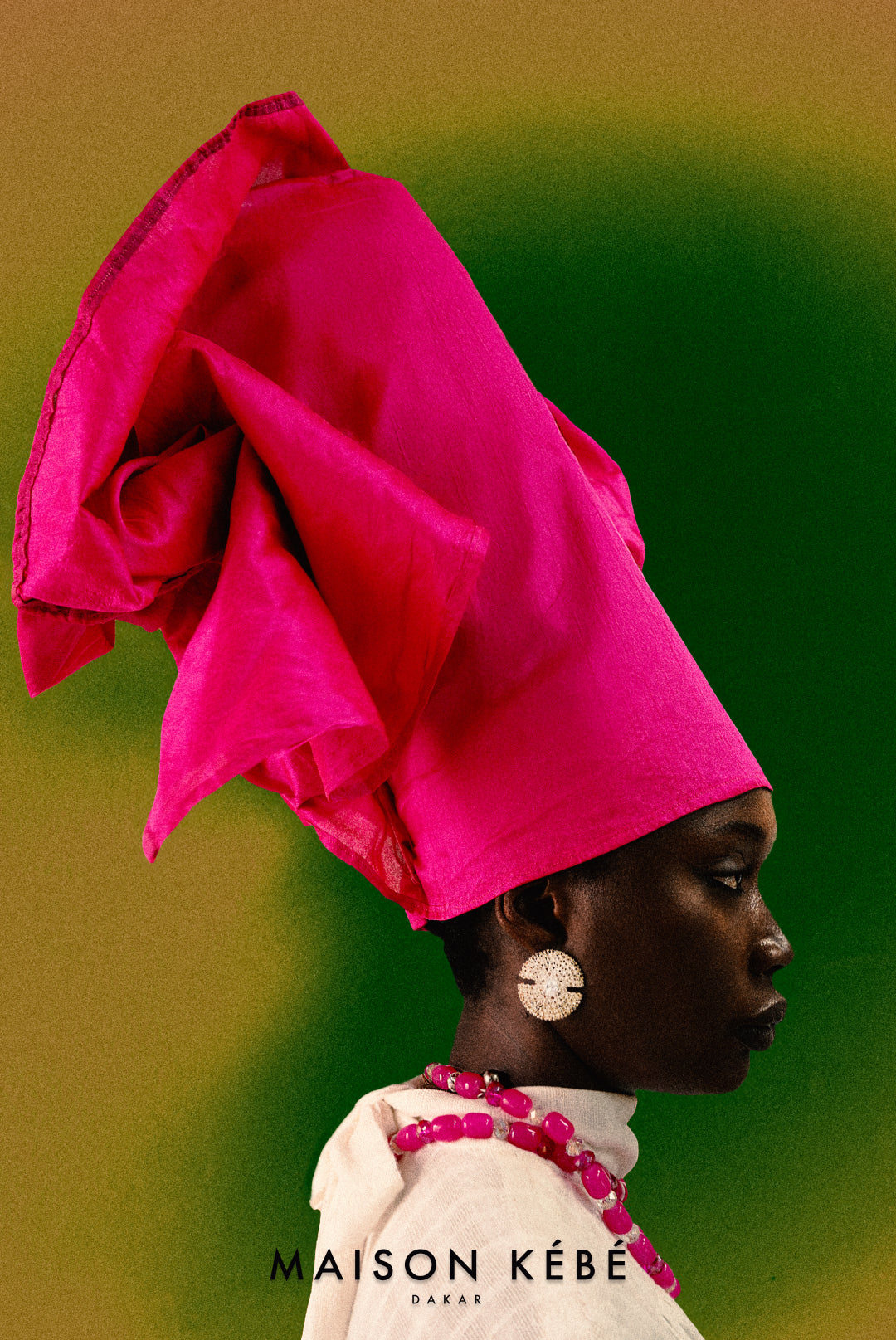Person wearing a bright pink magenta headwrap and beads with 'Maison Kebe' branding on a green background